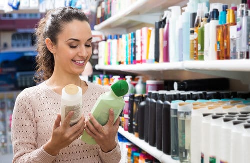 Girl choosing hair conditioner at store