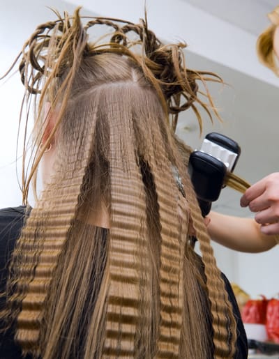 hairstylist using a hair crimping iron 